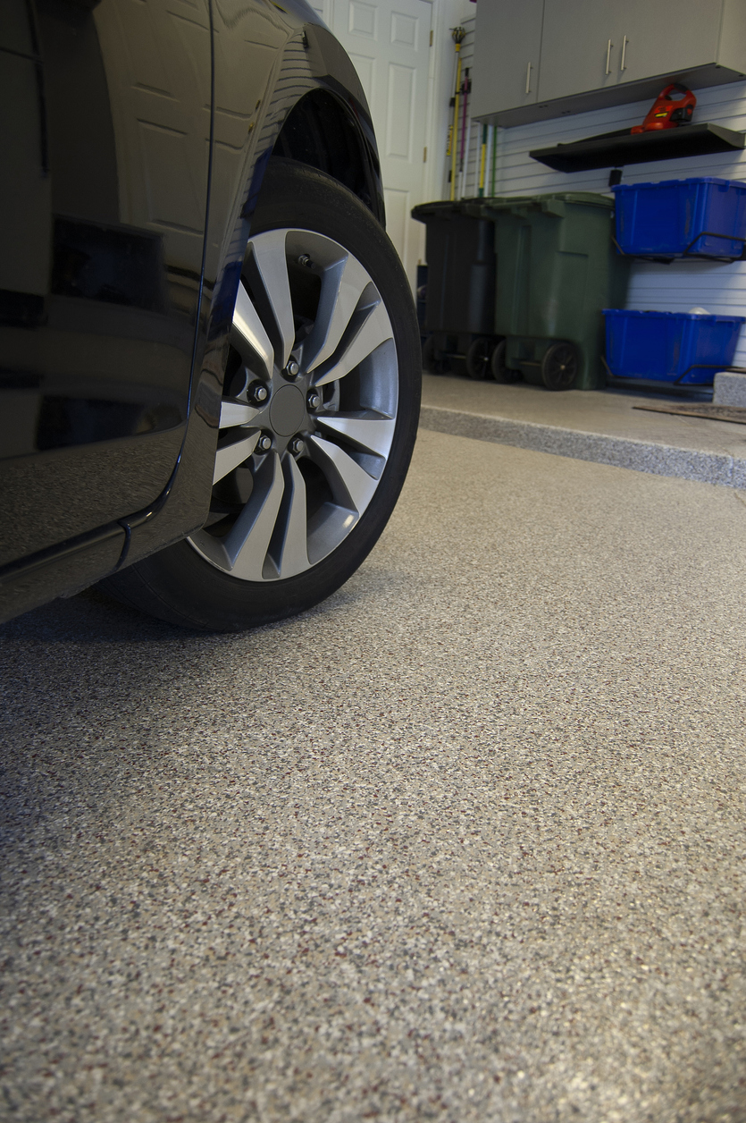 Epoxy or Polyasparitic Coating on Concrete Garage Floor with Wheel and Tire of Car visible